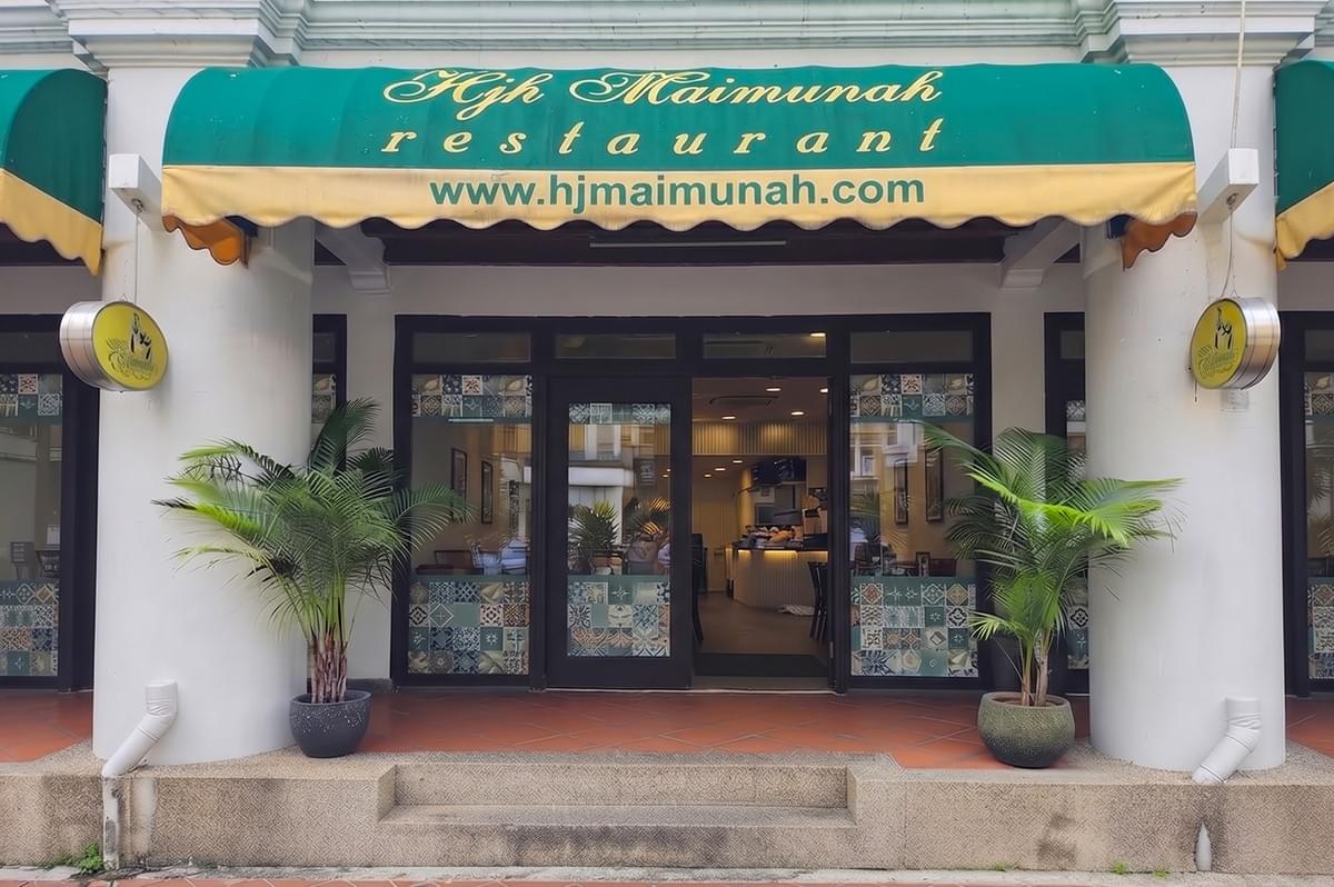 Hjh Maimunah Restaurant storefront with green awning and plants. Hjh Maimunah Restaurant storefront with green awning and plants.