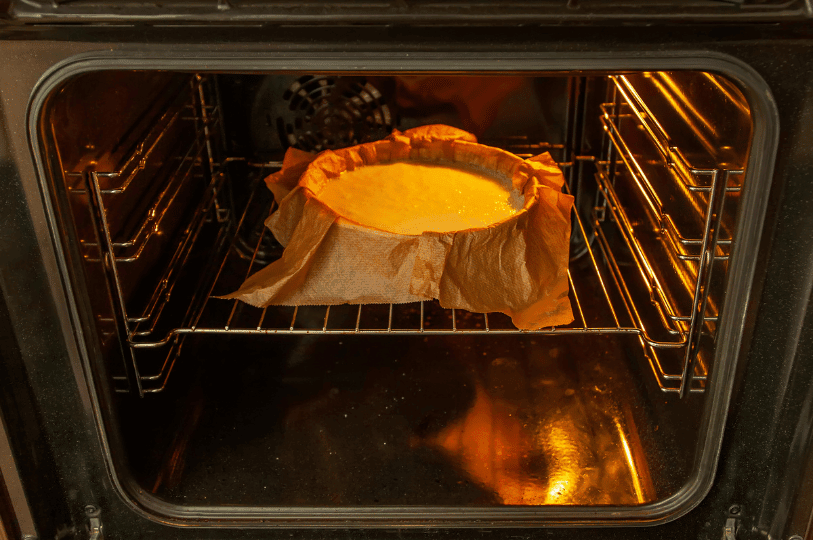 A round cake baking gently in a parchment-lined pan positioned on the center rack of a glowing oven, showcasing why accurate baking temperatures and proper rack placement really matter for a level, perfectly cooked cake center. A round cake baking gently in a parchment-lined pan positioned on the center rack of a glowing oven, showcasing why accurate baking temperatures and proper rack placement really matter for a level, perfectly cooked cake center.