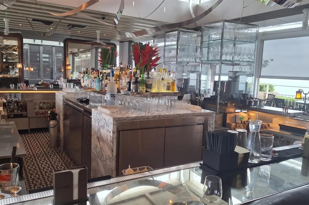 Spago Dining Room bar area with a marble counter, liquor bottles, and upscale glassware displays. Spago Dining Room bar area with a marble counter, liquor bottles, and upscale glassware displays.