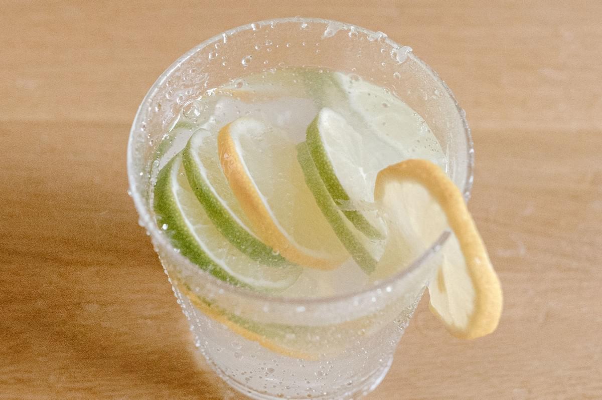 Fizzy Lemon Ribenna and refreshing cold drinks garnished with sliced lemon and lime in a glass on a wooden table. Fizzy Lemon Ribenna and refreshing cold drinks garnished with sliced lemon and lime in a glass on a wooden table.