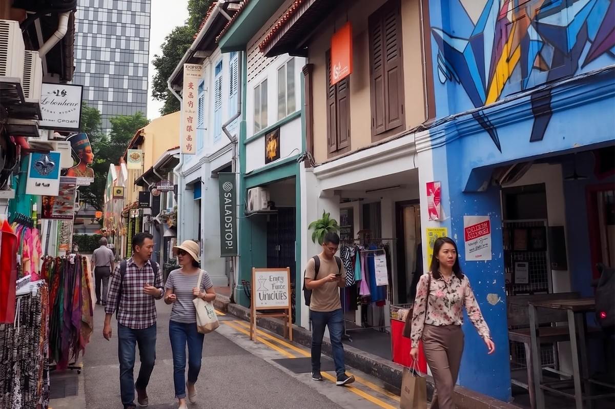 People walking through Haji Lane in Singapore, featuring colorful shophouses, street art, and boutique storefronts. People walking through Haji Lane in Singapore, featuring colorful shophouses, street art, and boutique storefronts.