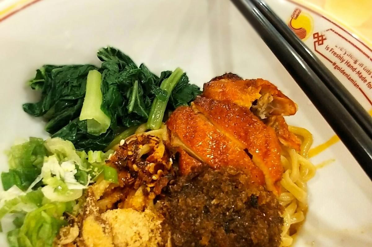 A plate of fusion food featuring chopsticks, showcasing a blend of flavors typical of Singaporean cuisine. A plate of fusion food featuring chopsticks, showcasing a blend of flavors typical of Singaporean cuisine.