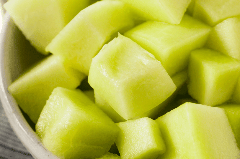 A close-up view of a bowl filled with freshly diced, pale green honeydew melon cubes, looking cool and hydrating. A close-up view of a bowl filled with freshly diced, pale green honeydew melon cubes, looking cool and hydrating.