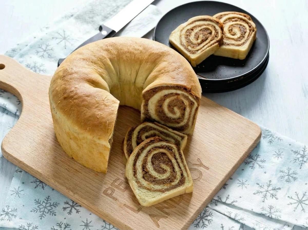 Set against a festive winter-blue snowflake backdrop, this cleanly styled golden ring loaf radiates a cozy, holiday-morning vibe with its perfectly defined, warm walnut swirls. Set against a festive winter-blue snowflake backdrop, this cleanly styled golden ring loaf radiates a cozy, holiday-morning vibe with its perfectly defined, warm walnut swirls.