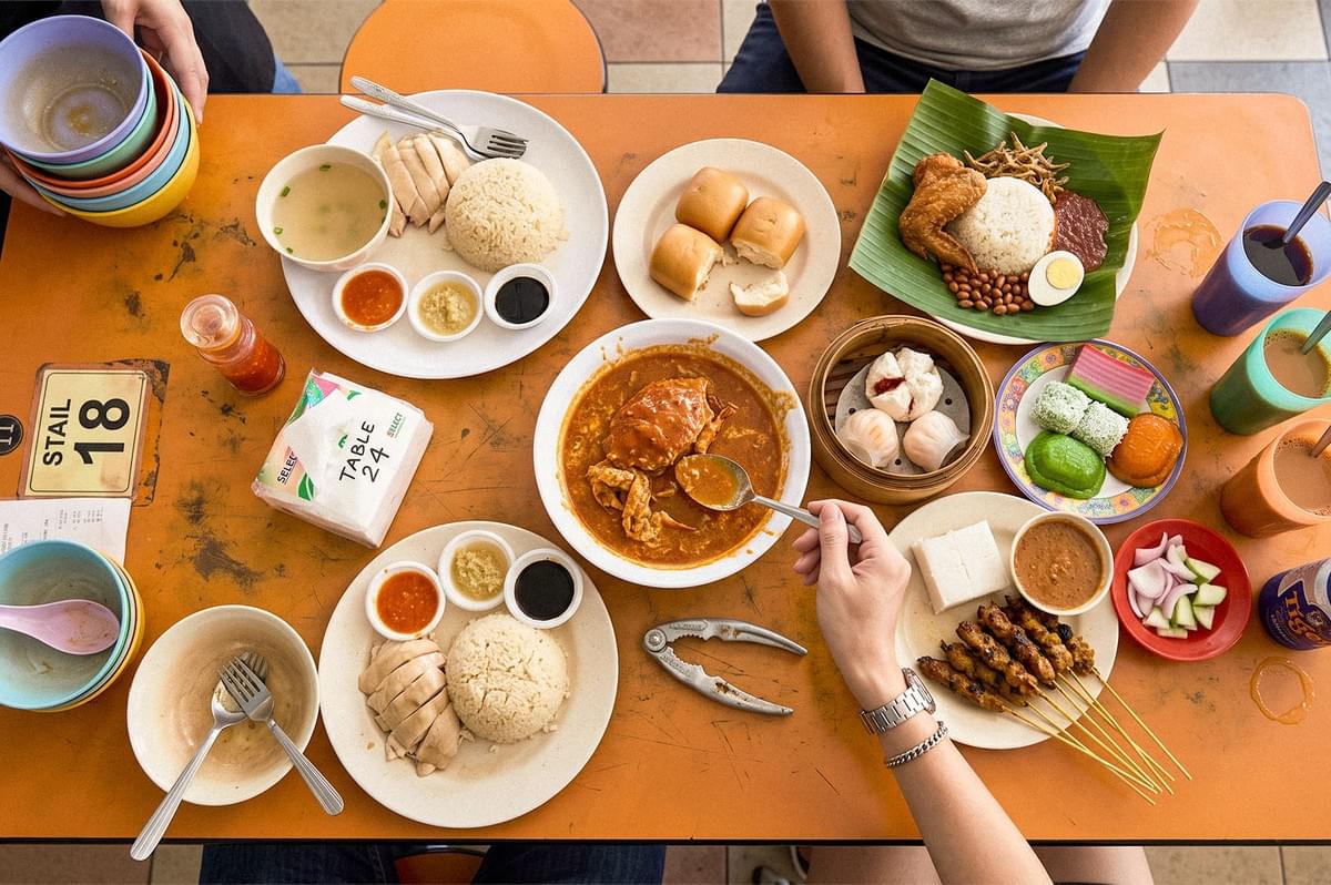 A table filled with assorted Southeast Asian dishes, including chicken rice, curry, satay, dim sum, rice, and colorful desserts. A table filled with assorted Southeast Asian dishes, including chicken rice, curry, satay, dim sum, rice, and colorful desserts.
