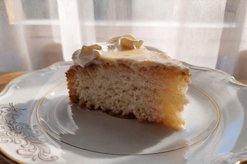 A delicate slice of classic Tres Leches cake on an elegant gold-rimmed china plate, bathed in soft morning sunlight that emphasizes its moist, light texture. A delicate slice of classic Tres Leches cake on an elegant gold-rimmed china plate, bathed in soft morning sunlight that emphasizes its moist, light texture.