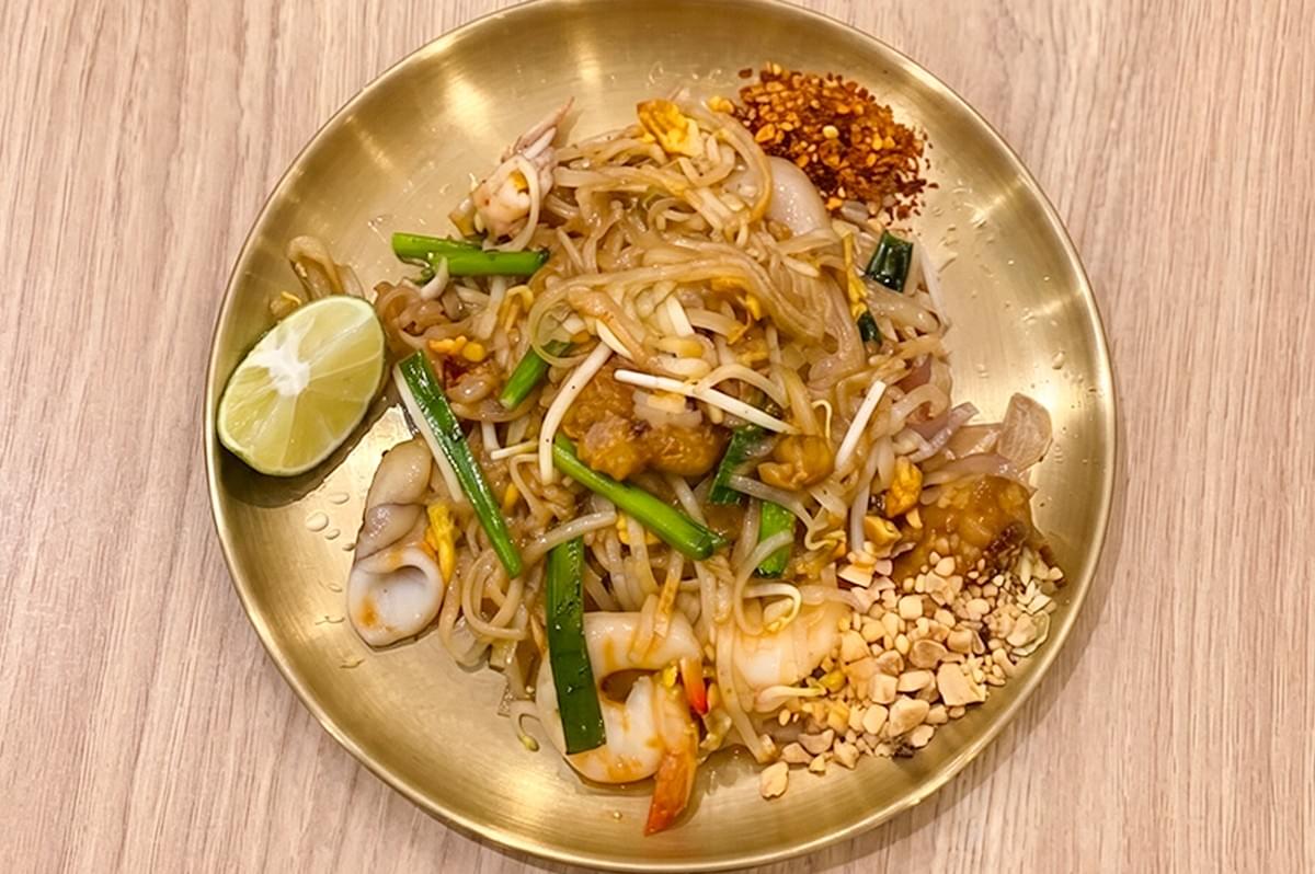Pad Thai Noodle with Prawn served on a gold plate with lime and peanuts. Pad Thai Noodle with Prawn served on a gold plate with lime and peanuts.