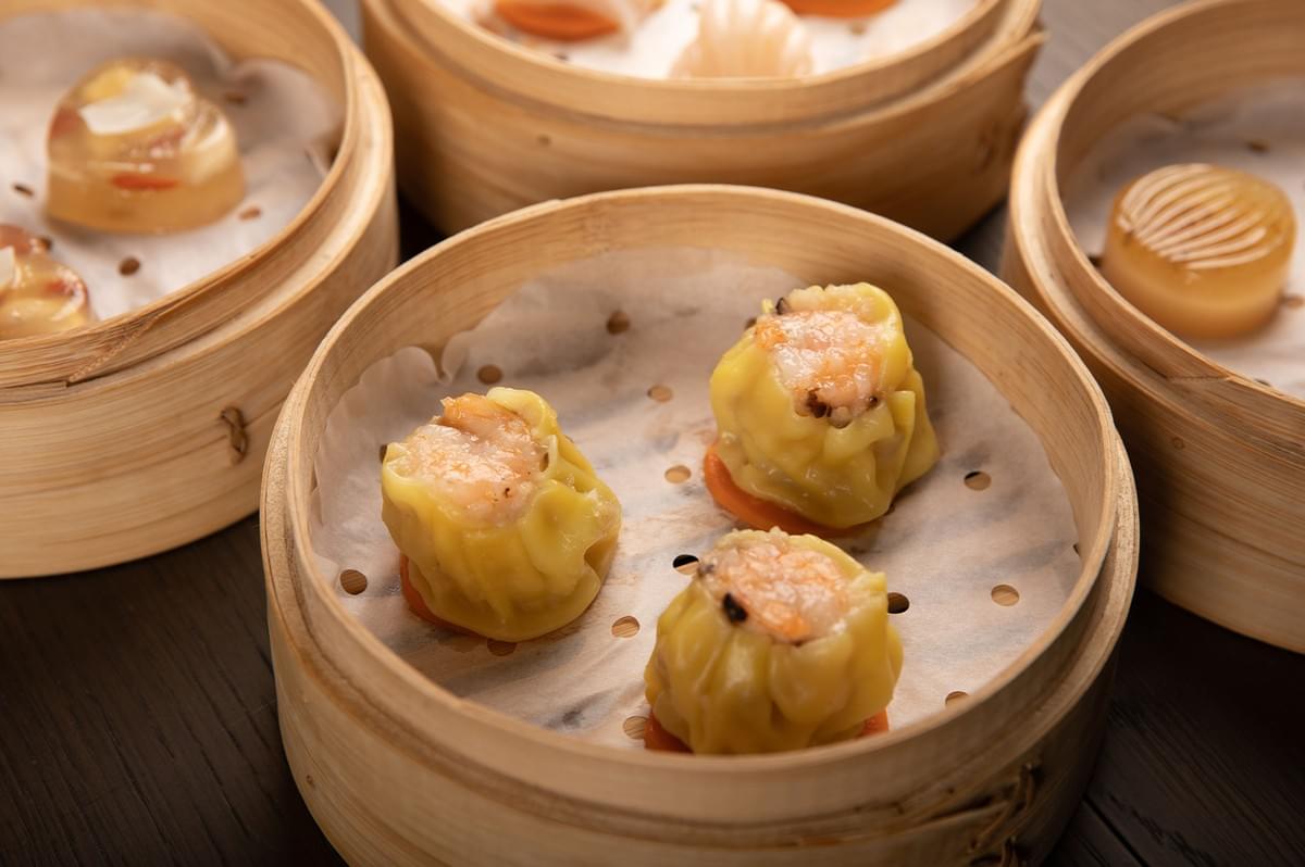 Assorted dim sum and chicken dumplings including siew mai served in bamboo steamer baskets. Assorted dim sum and chicken dumplings including siew mai served in bamboo steamer baskets.