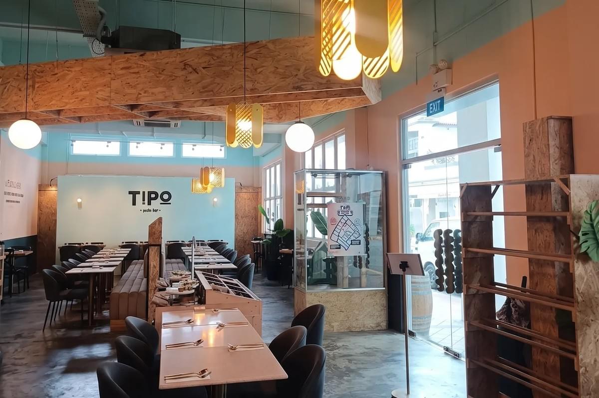 The interior of Tipo Pasta Bar, featuring a modern, minimalist design with light blue walls, wood accents, and stylish pendant lighting. The interior of Tipo Pasta Bar, featuring a modern, minimalist design with light blue walls, wood accents, and stylish pendant lighting.