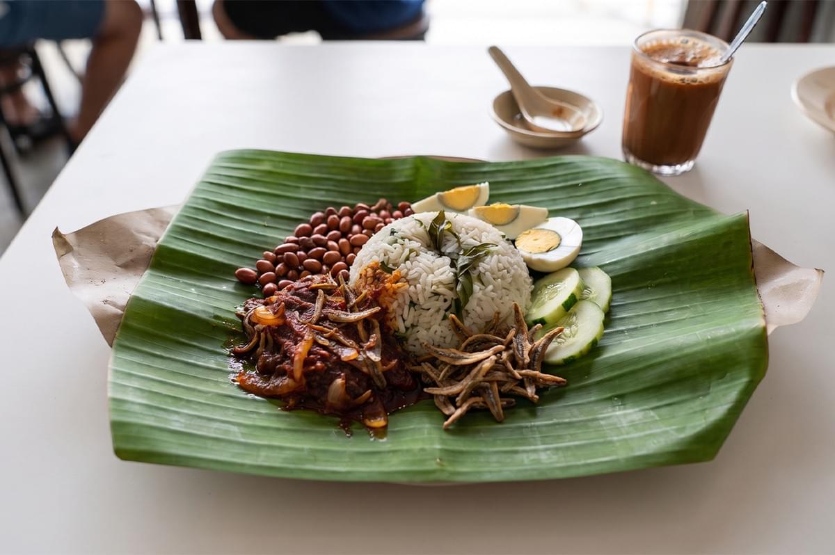 Traditional Nasi Lemak served on a banana leaf with coconut rice, sambal, fried anchovies, peanuts, and hard-boiled egg. Traditional Nasi Lemak served on a banana leaf with coconut rice, sambal, fried anchovies, peanuts, and hard-boiled egg.