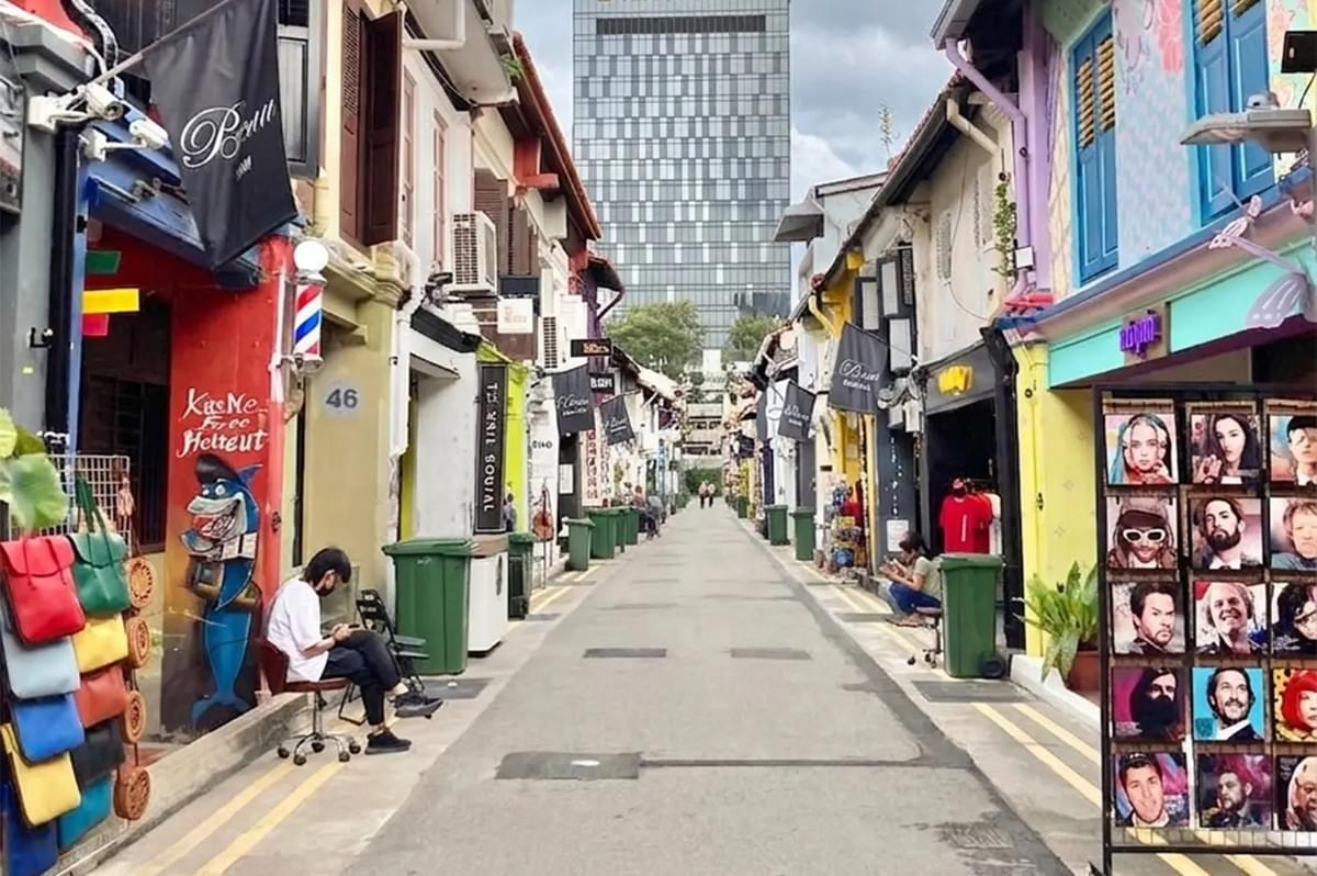 A quiet morning view of Haji Lane in Singapore with colorful shophouses, street art murals, and a modern skyscraper in the background. A quiet morning view of Haji Lane in Singapore with colorful shophouses, street art murals, and a modern skyscraper in the background.