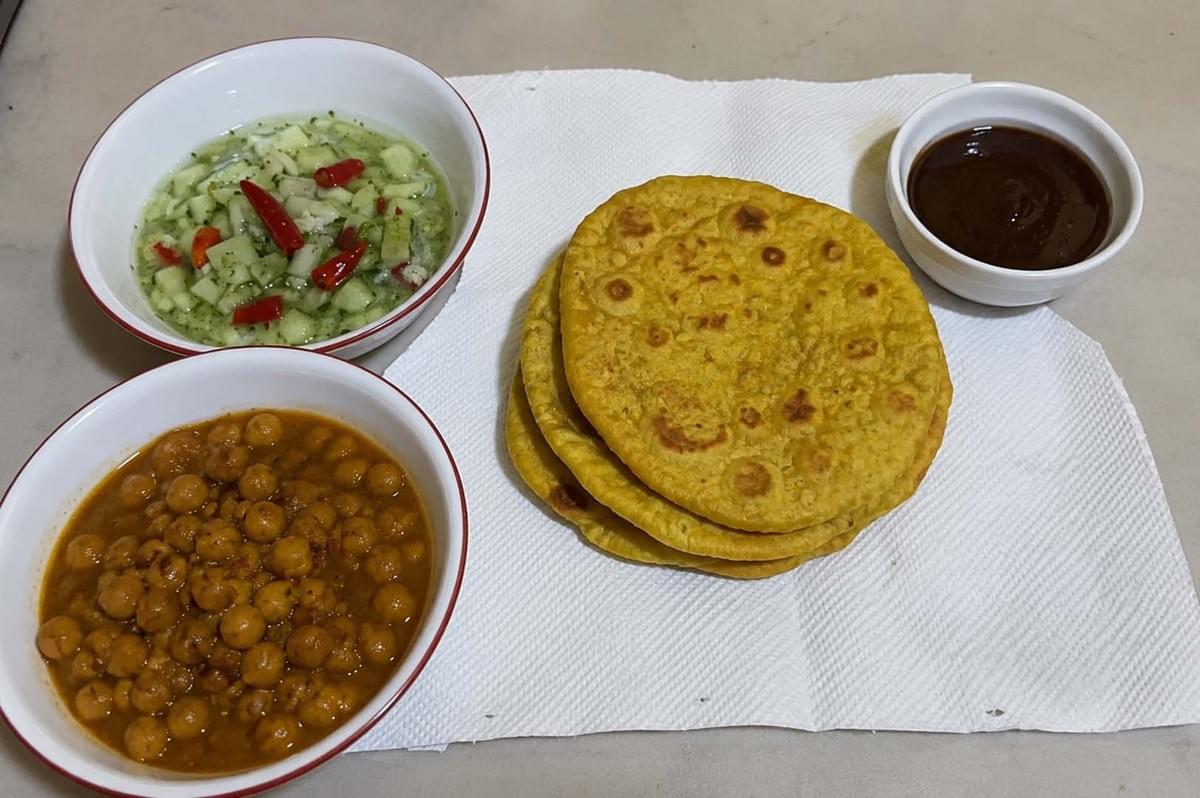 Complete doubles meal with channa, bara, and condiments Complete doubles meal with channa, bara, and condiments