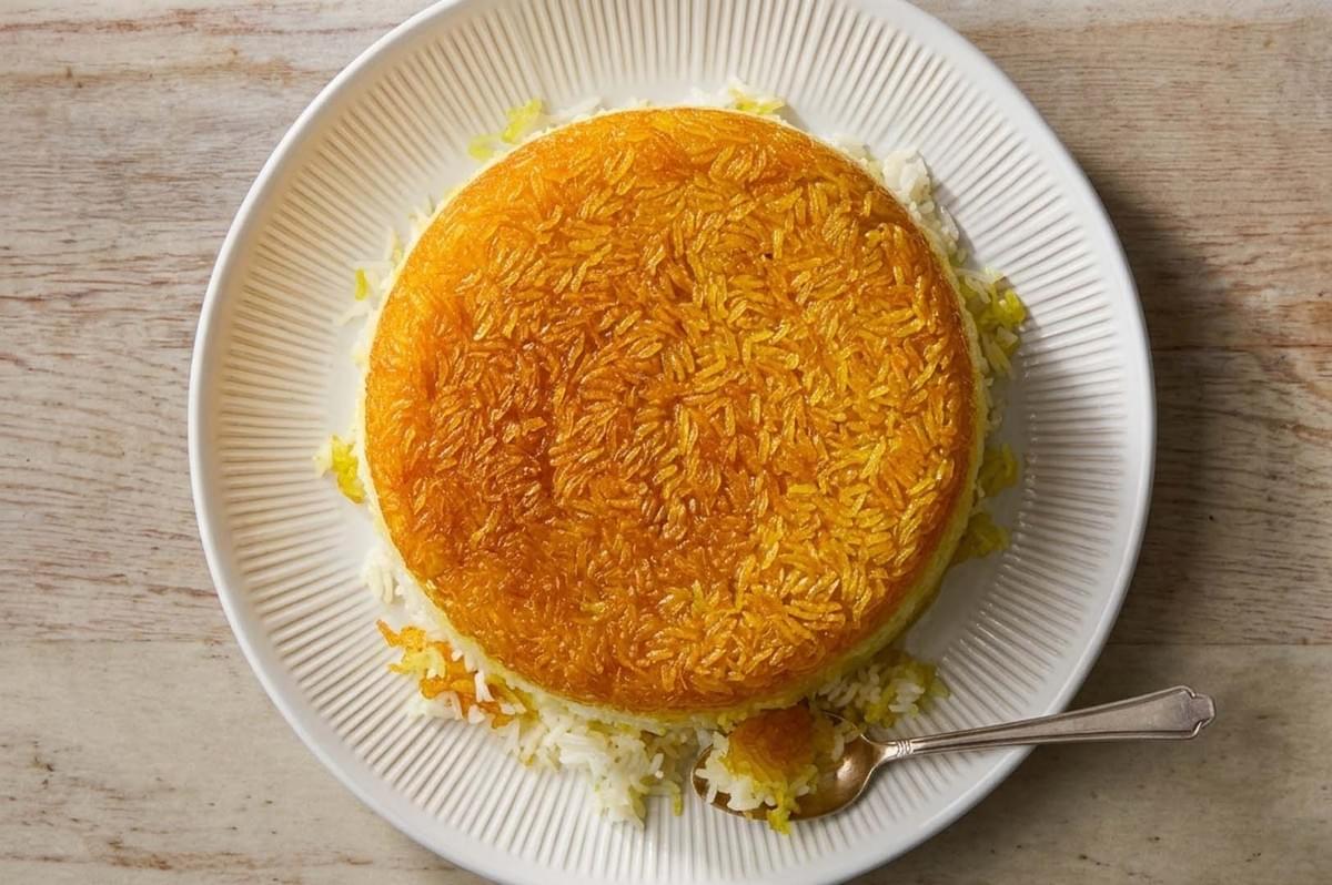 Golden Tahdig rice crust flipped onto a white plate Golden Tahdig rice crust flipped onto a white plate