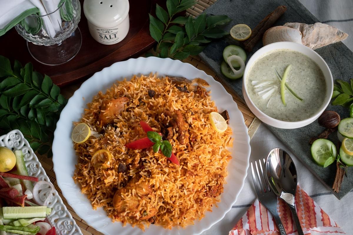 Halal chicken biryani with rice and side dishes in a restaurant in Singapore. Halal chicken biryani with rice and side dishes in a restaurant in Singapore.