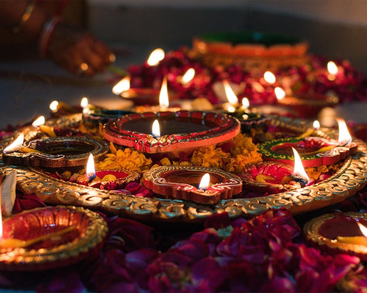 Rows of glowing oil lamps placed along the floor, creating a warm and peaceful Deepavali celebration atmosphere. Rows of glowing oil lamps placed along the floor, creating a warm and peaceful Deepavali celebration atmosphere.