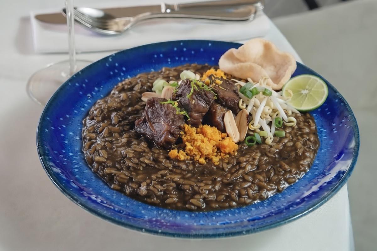 Wagyu Beef Cheeks with Lemak Chilli Padi rigatoni pasta served in a fine dining bowl with grated cheese and microgreens. Wagyu Beef Cheeks with Lemak Chilli Padi rigatoni pasta served in a fine dining bowl with grated cheese and microgreens.