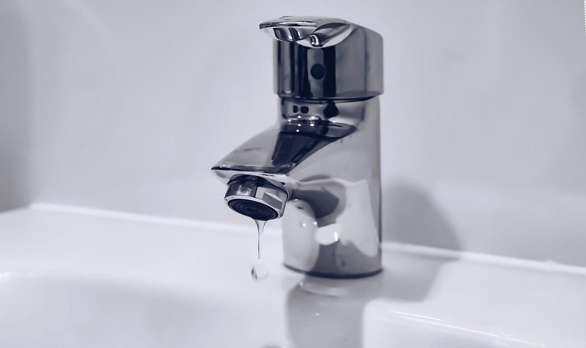 A dripping tap in a hand basin A dripping tap in a hand basin