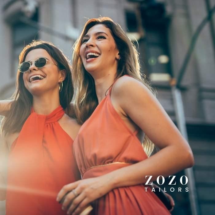 Two stylishly dressed women smile in the city sunlight—showcasing how tailored garments can express personality and joy. Two stylishly dressed women smile in the city sunlight—showcasing how tailored garments can express personality and joy.