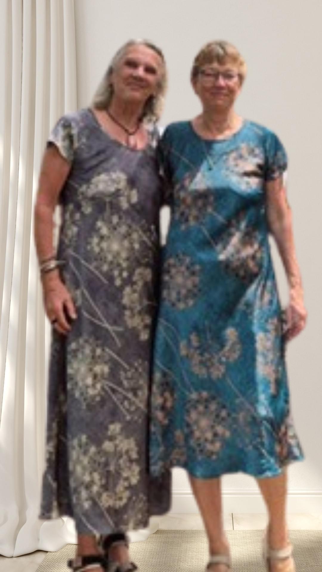 Two friends on a tailoring holiday — each in a different-shade silk shift dress, sharing  vacation memories and self-expression. Two friends on a tailoring holiday — each in a different-shade silk shift dress, sharing  vacation memories and self-expression.