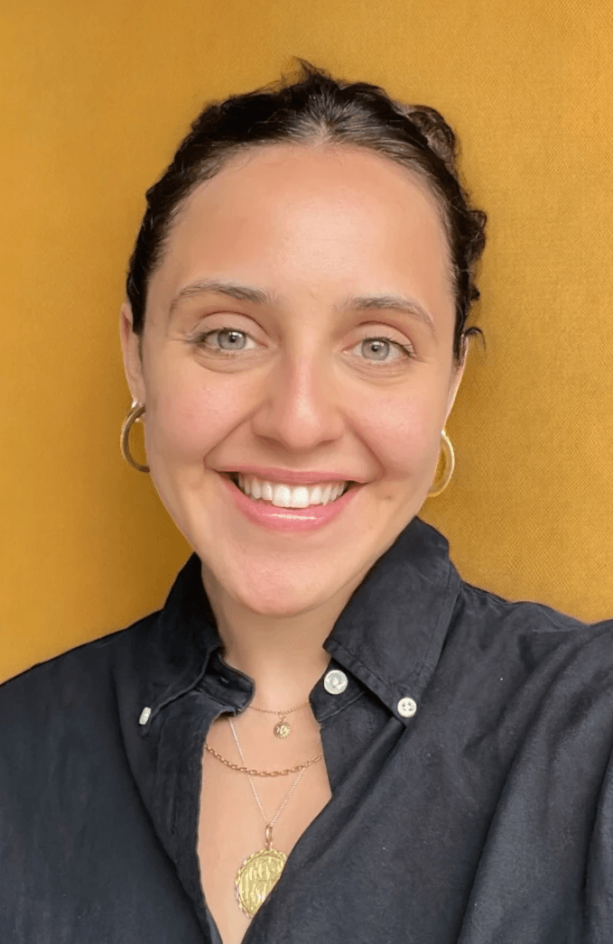Smiling woman with hair pulled back wearing dark shirt and gold jewellery Smiling woman with hair pulled back wearing dark shirt and gold jewellery