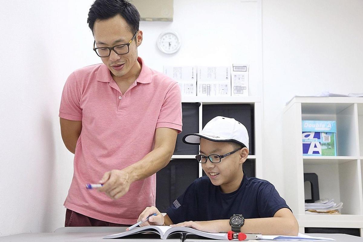 PSLE Math tuition teacher guiding a student during a math lesson in Singapore PSLE Math tuition teacher guiding a student during a math lesson in Singapore