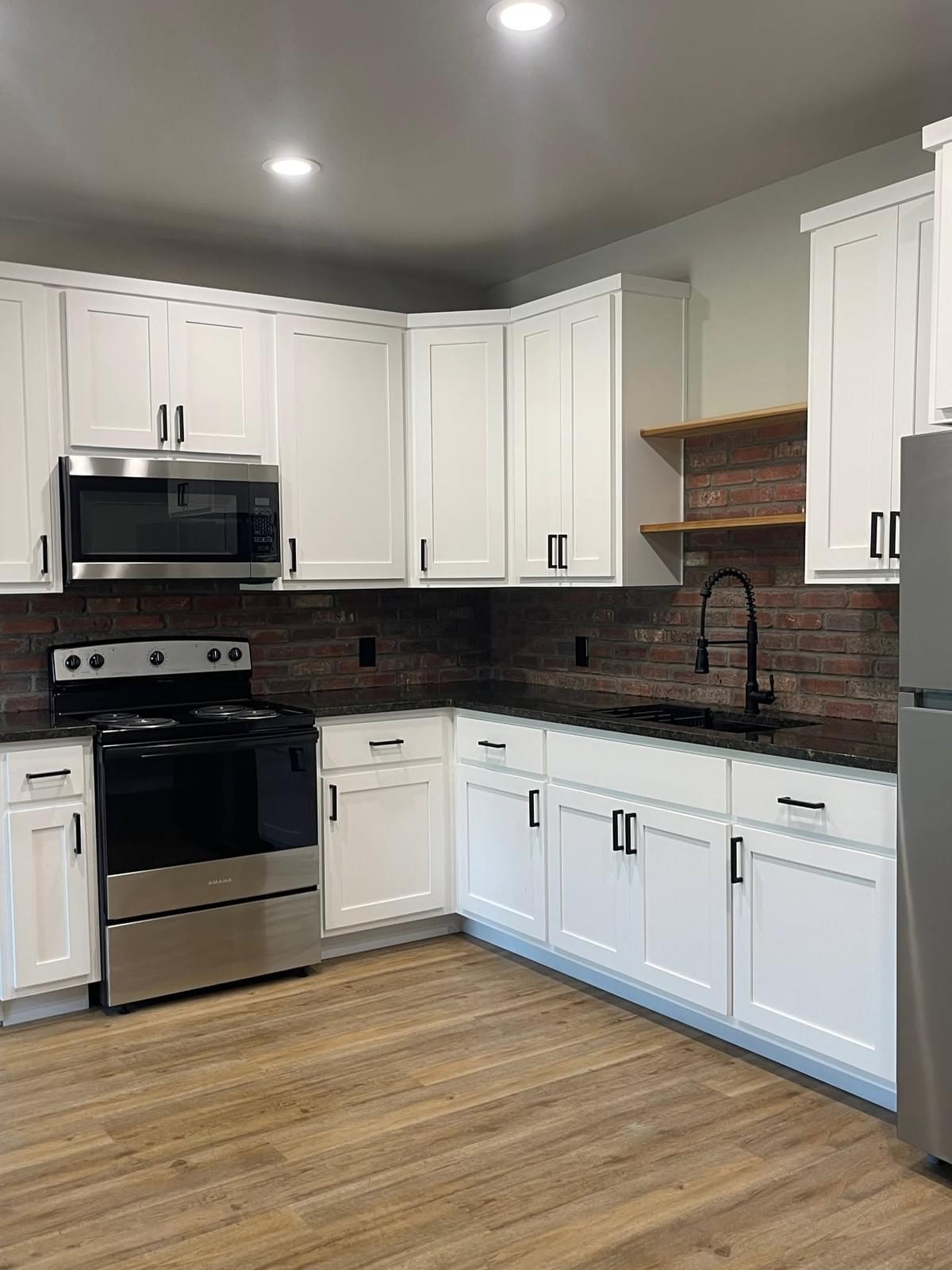 Renovated kitchen with white cabinets and exposed brick backsplash, featured on the Oak Harbor blog Renovated kitchen with white cabinets and exposed brick backsplash, featured on the Oak Harbor blog