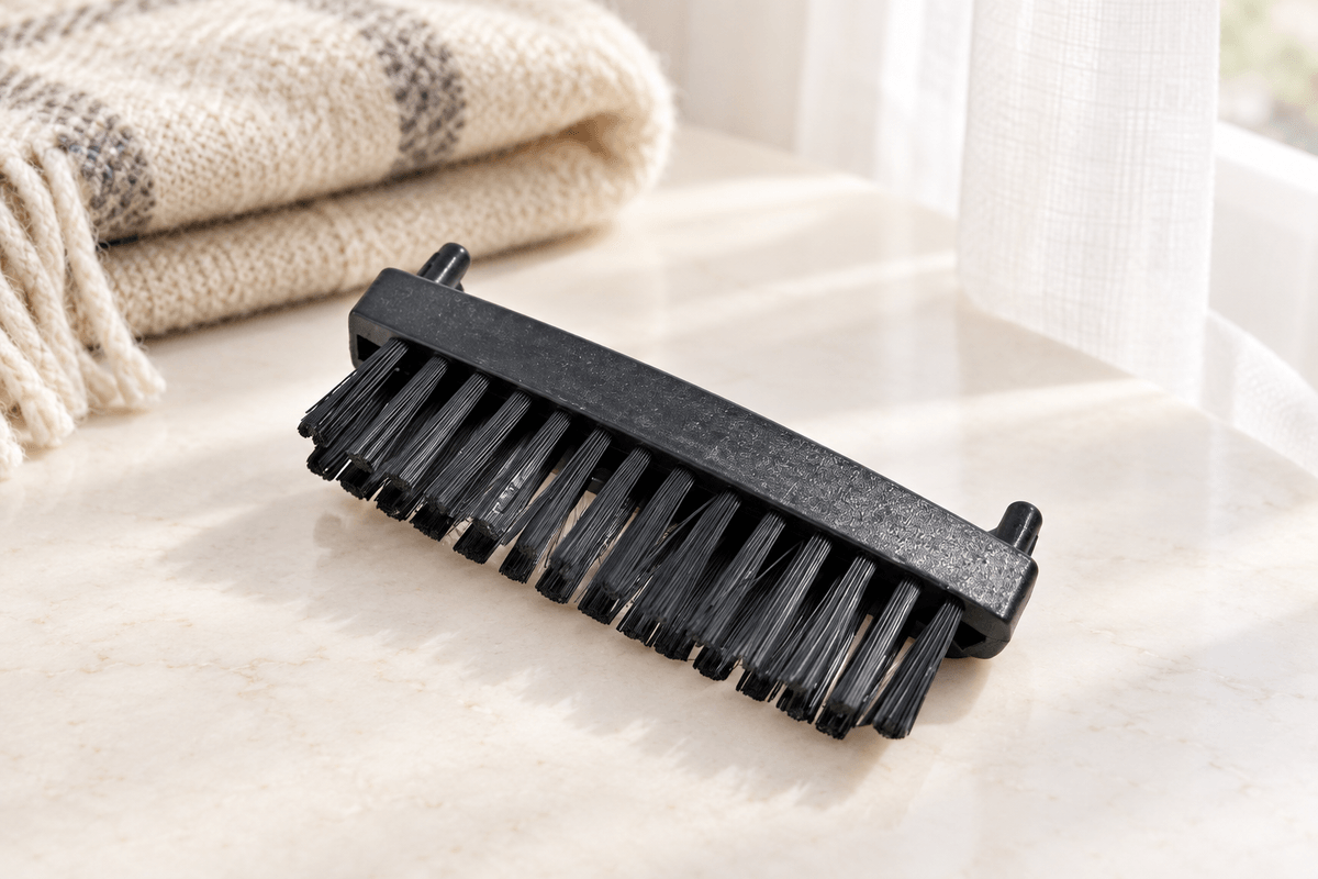 Brosse : Brosse nylon noire du Steam-it présentée près d’un plaid et d’un voilage. Brosse : Brosse nylon noire du Steam-it présentée près d’un plaid et d’un voilage.