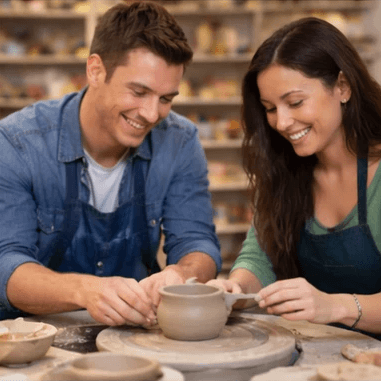Couple learning wheel throwing together during a private pottery experience Couple learning wheel throwing together during a private pottery experience