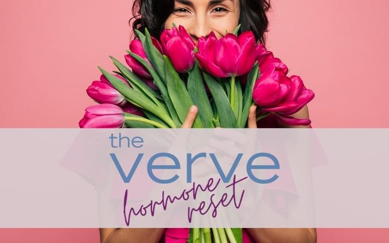 A woman stand infron t of a pink background holding a bunch of tulips. The text says The Verve Hormone Reset A woman stand infron t of a pink background holding a bunch of tulips. The text says The Verve Hormone Reset