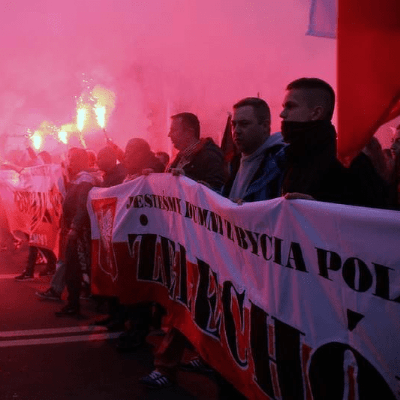 a picture of a group of men holding a banner at a demonstration with torches a picture of a group of men holding a banner at a demonstration with torches