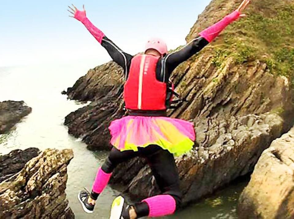 Person in a tutu jumping from cliffs into the sea, coasteering Person in a tutu jumping from cliffs into the sea, coasteering