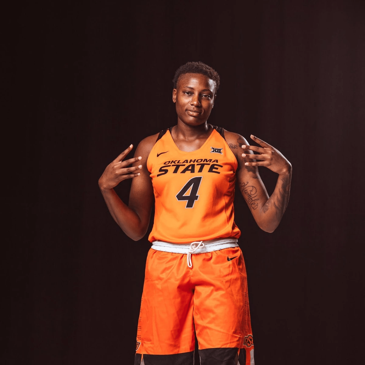 Natasha puts up for fingers on each hand wearing #4 Oklahoma state jersey Natasha puts up for fingers on each hand wearing #4 Oklahoma state jersey