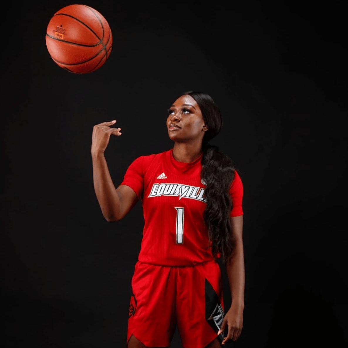 Dana throws ball in the air wearing Louisville red uniform Dana throws ball in the air wearing Louisville red uniform