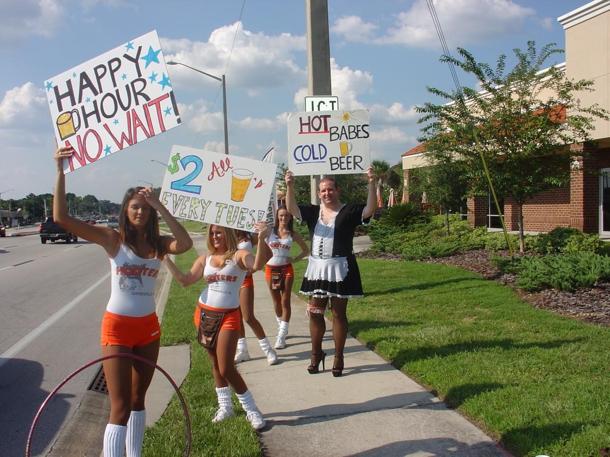 On display for all to see as he holds signs to promote the Gainesville, Fla. Hooters store along the side of a major roadway during rush hour On display for all to see as he holds signs to promote the Gainesville, Fla. Hooters store along the side of a major roadway during rush hour