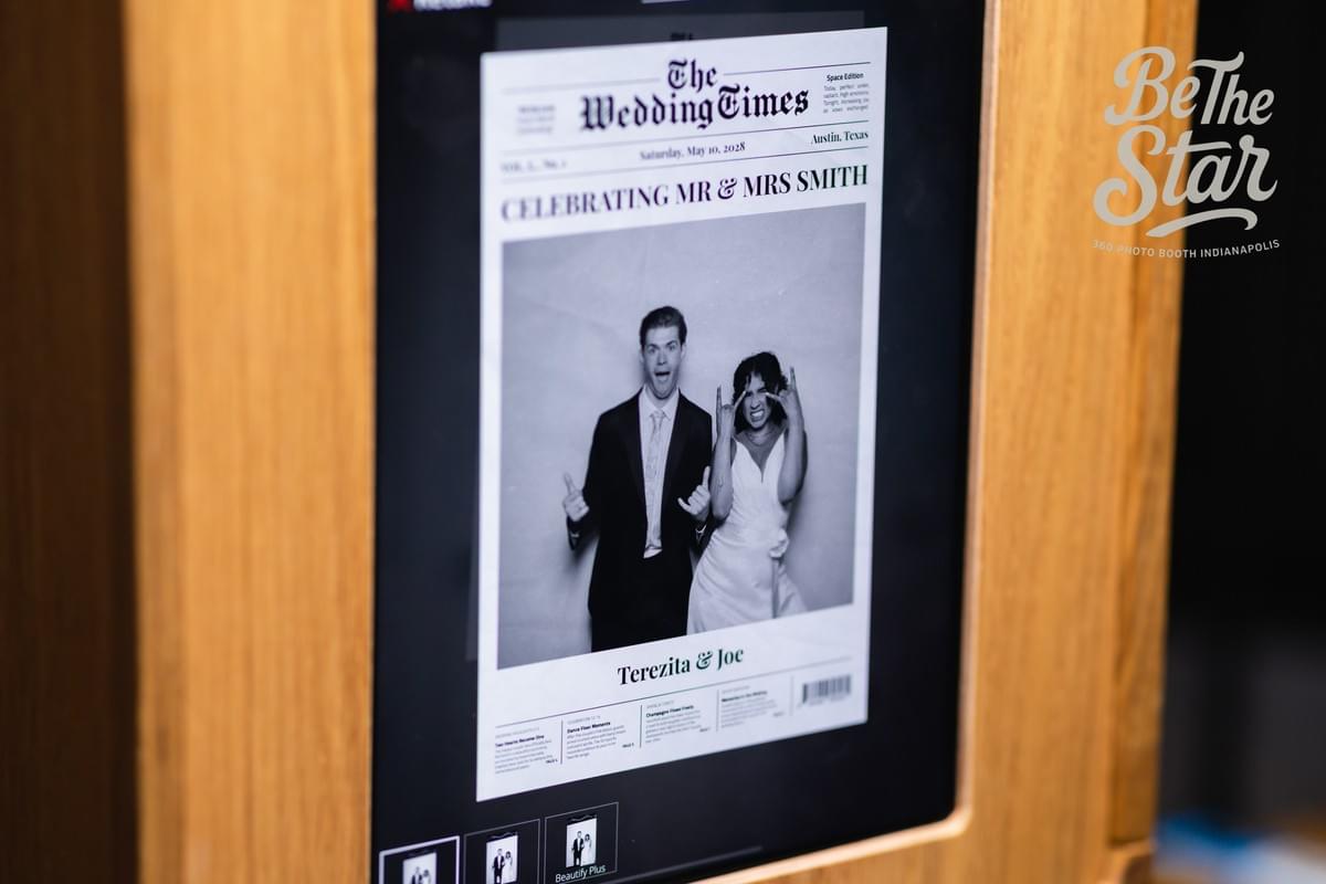 Wedding couple posing in a newspaper-style photo booth experience with a custom front-page design. Wedding couple posing in a newspaper-style photo booth experience with a custom front-page design.