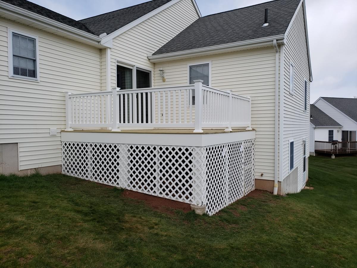 Photo of Lumber deck with PVC railings and framed lattice with door Photo of Lumber deck with PVC railings and framed lattice with door