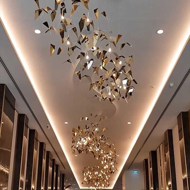 Artistic origami bird chandelier in gold for boutique hotel lobby Artistic origami bird chandelier in gold for boutique hotel lobby