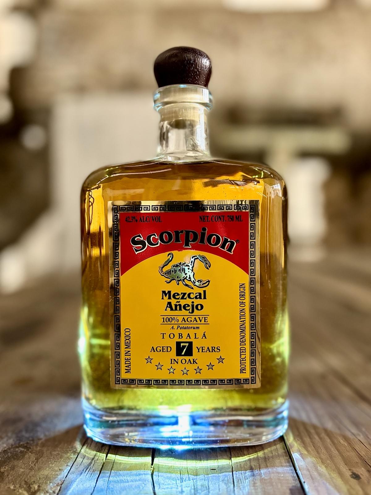 0mL bottle of Scorpion Mezcal Tobalá 7 Year Extra Añejo on a rustic wooden table. 0mL bottle of Scorpion Mezcal Tobalá 7 Year Extra Añejo on a rustic wooden table.