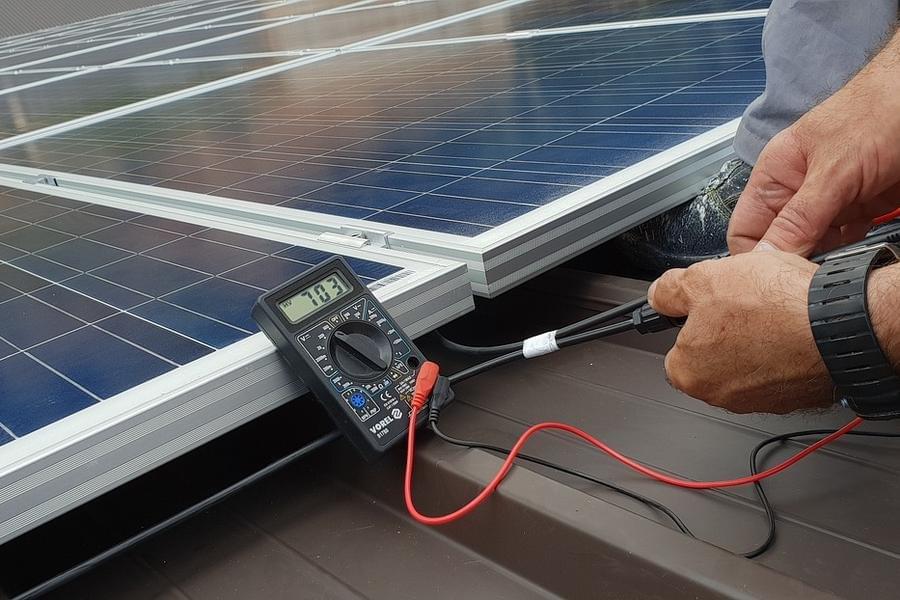 Verifica manuale dei collegamenti elettrici su un pannello fotovoltaico per identificare guasti invisibili al sistema di monitoraggio. Verifica manuale dei collegamenti elettrici su un pannello fotovoltaico per identificare guasti invisibili al sistema di monitoraggio.