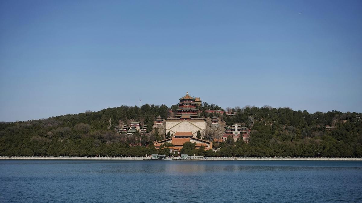 The Summer Palace's ornate pavilions and towers reflected in the calm waters of Kunming Lake under a bright sky The Summer Palace's ornate pavilions and towers reflected in the calm waters of Kunming Lake under a bright sky