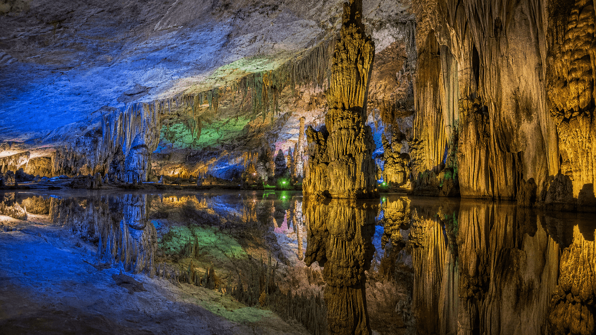 Colorful stalactites and underground reflections inside Reed Flute Cave in Guilin Colorful stalactites and underground reflections inside Reed Flute Cave in Guilin