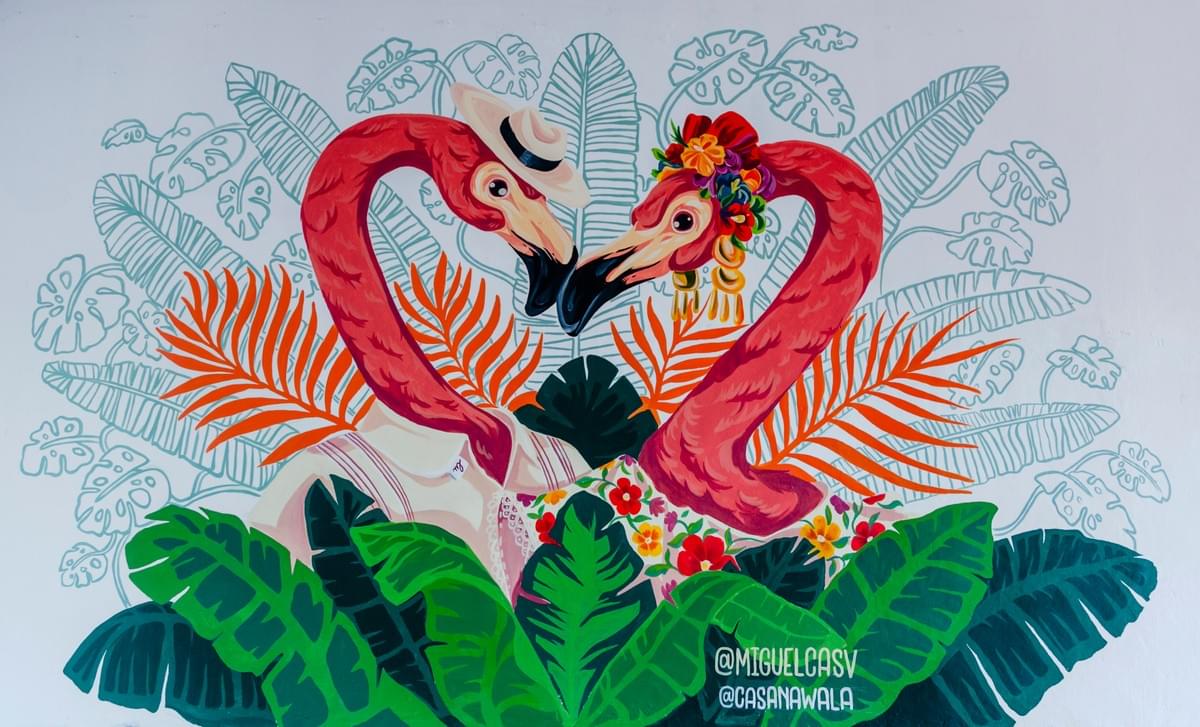 Playful flamingo mural by Miguel Castillo featuring two flamingos forming a heart shape surrounded by tropical leaves, flowers, and colorful coastal inspired patterns in Cancún, Mexico. Playful flamingo mural by Miguel Castillo featuring two flamingos forming a heart shape surrounded by tropical leaves, flowers, and colorful coastal inspired patterns in Cancún, Mexico.