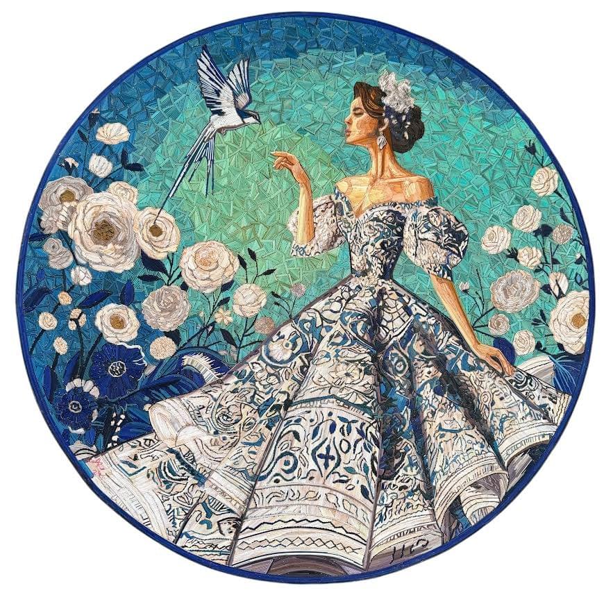 Circular popotillo artwork by Ariosto Rivera featuring a Mexican woman in an elaborate blue and white dress surrounded by blooming flowers and a bird in flight. Circular popotillo artwork by Ariosto Rivera featuring a Mexican woman in an elaborate blue and white dress surrounded by blooming flowers and a bird in flight.