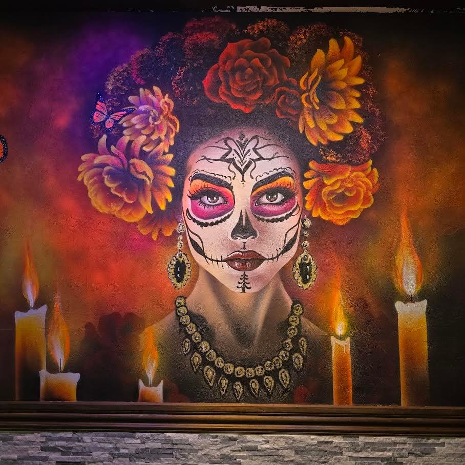 Painting by California artist Sergio Martinez “Checkos” featuring a Día de los Muertos inspired female portrait with colorful floral headpiece, candlelight, and detailed calavera face makeup against a dark glowing background. Painting by California artist Sergio Martinez “Checkos” featuring a Día de los Muertos inspired female portrait with colorful floral headpiece, candlelight, and detailed calavera face makeup against a dark glowing background.