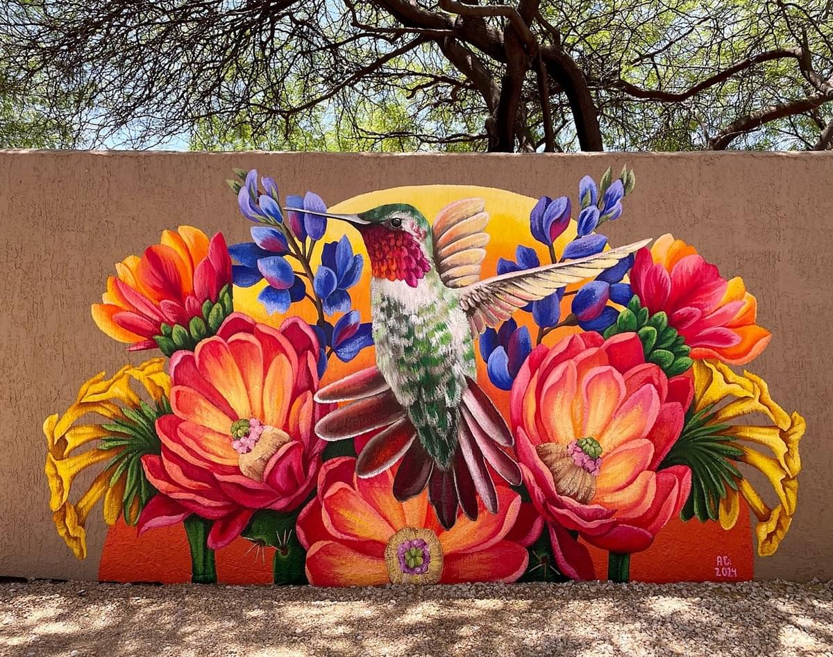 Colorful mural by Ariana Enriquez featuring an Anna's hummingbird surrounded by vibrant Sonoran Desert wildflowers inspired by Arizona's native flora and wildlife. Colorful mural by Ariana Enriquez featuring an Anna's hummingbird surrounded by vibrant Sonoran Desert wildflowers inspired by Arizona's native flora and wildlife.