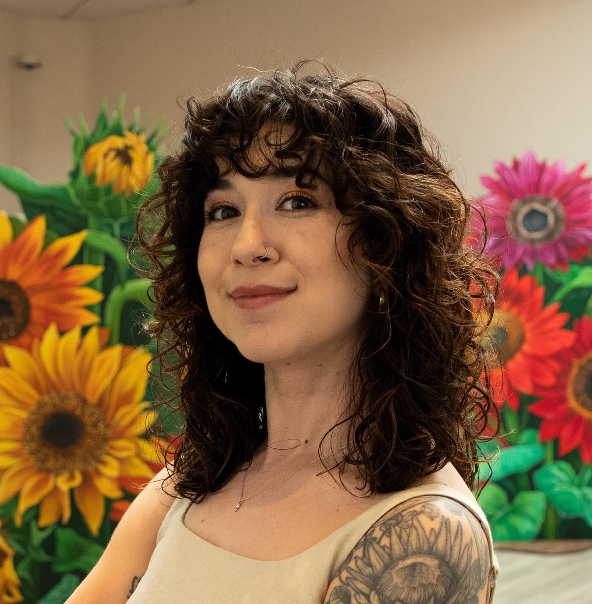 Portrait of Phoenix artist Ariana Enriquez in front of her colorful sunflower paintings, known for murals and fine art inspired by the Sonoran Desert and Arizona's native wildlife. Portrait of Phoenix artist Ariana Enriquez in front of her colorful sunflower paintings, known for murals and fine art inspired by the Sonoran Desert and Arizona's native wildlife.