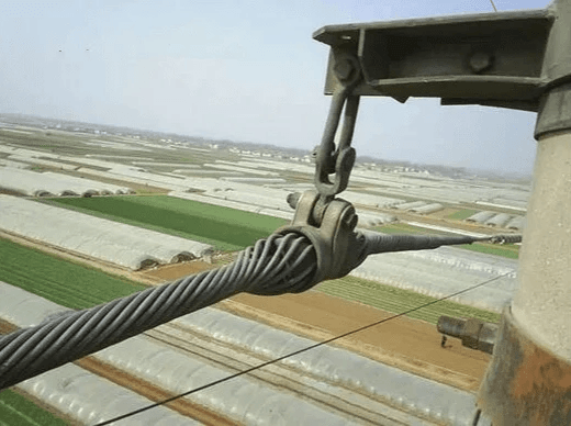 Inspecting electrical guy wire for wear and tear. Inspecting electrical guy wire for wear and tear.