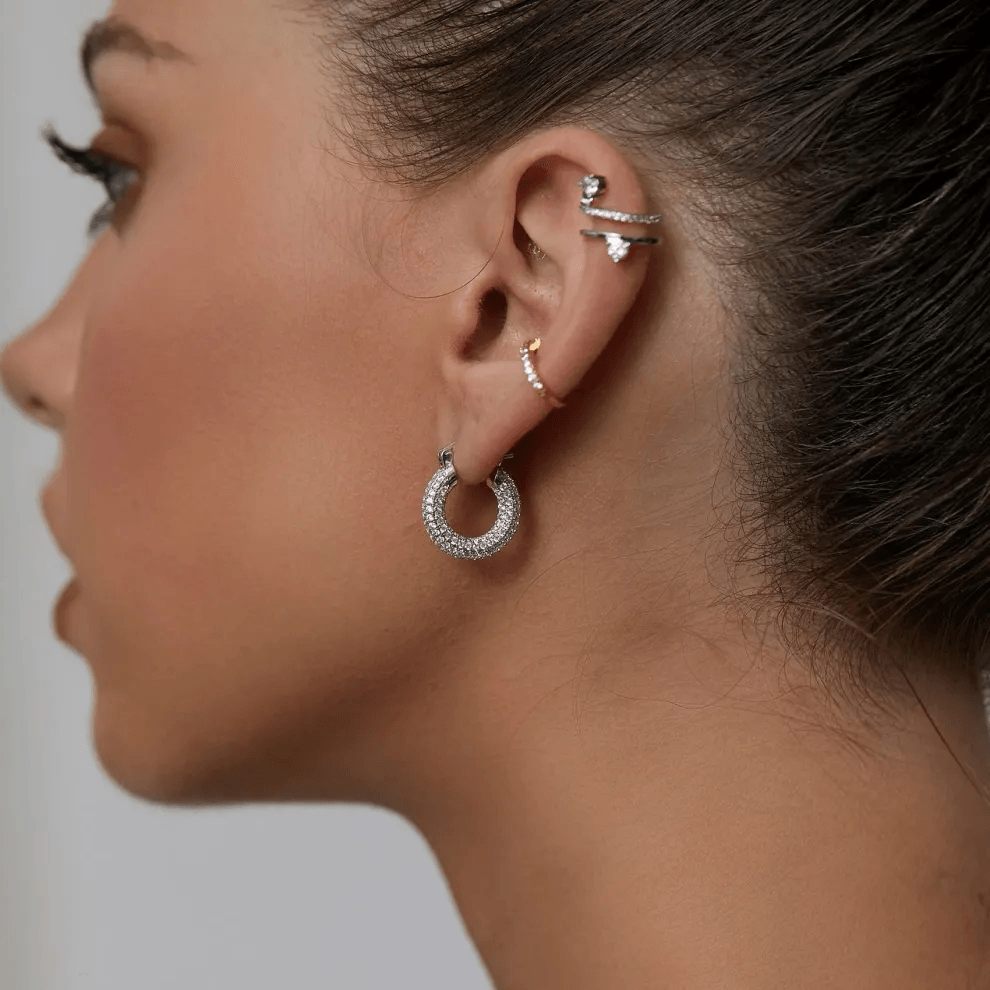 Stylish gold stud earrings on display in jewelry store window Stylish gold stud earrings on display in jewelry store window