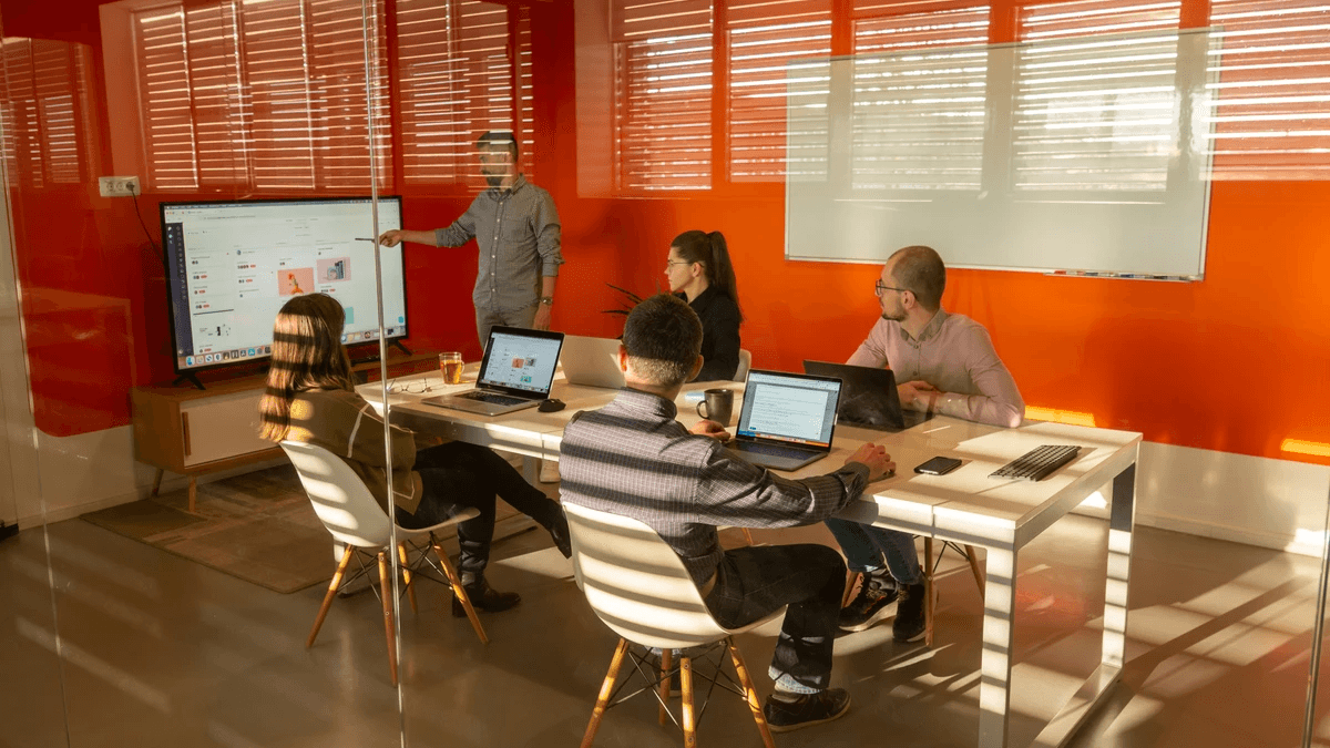 A project team reviewing work and results together around a table A project team reviewing work and results together around a table