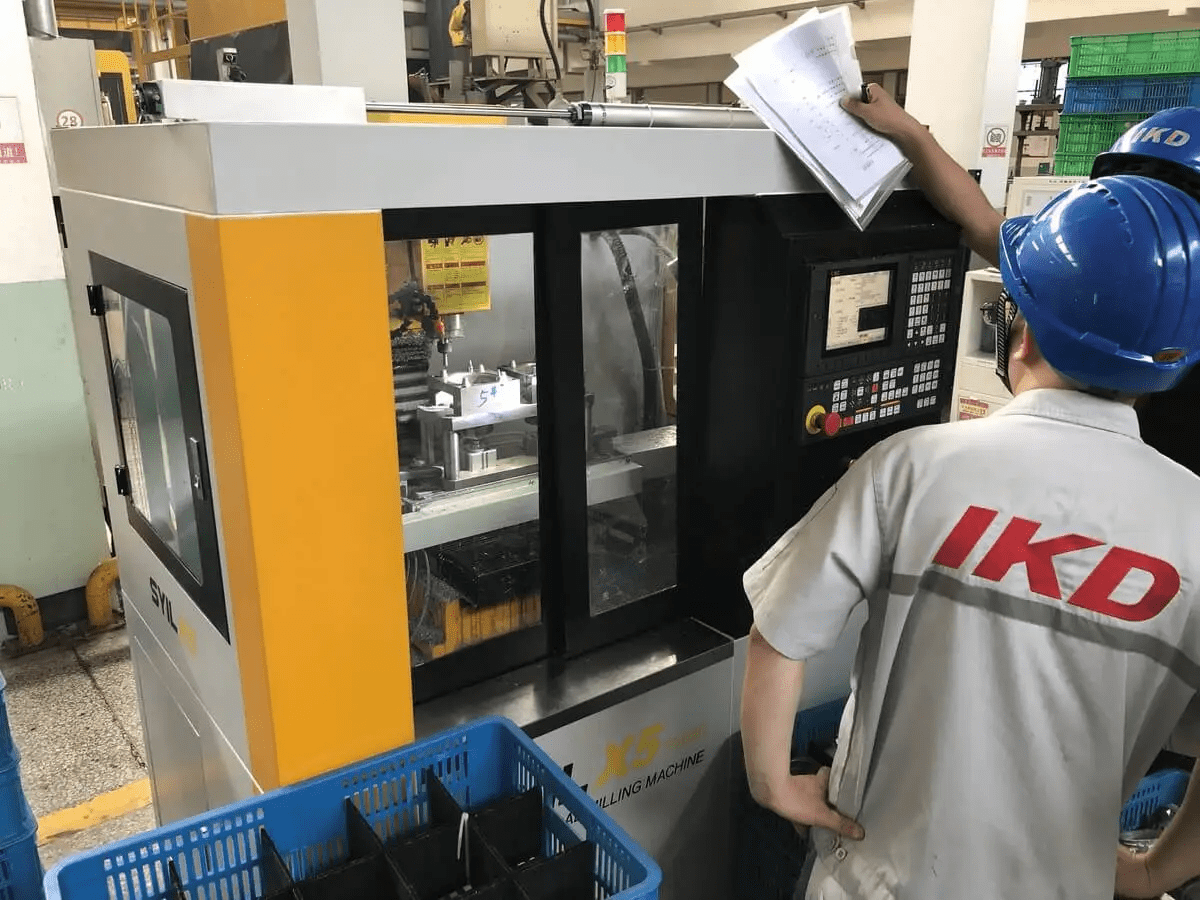 An operator working with precision on a SYIL CNC machine to reduce machining cost per hour An operator working with precision on a SYIL CNC machine to reduce machining cost per hour